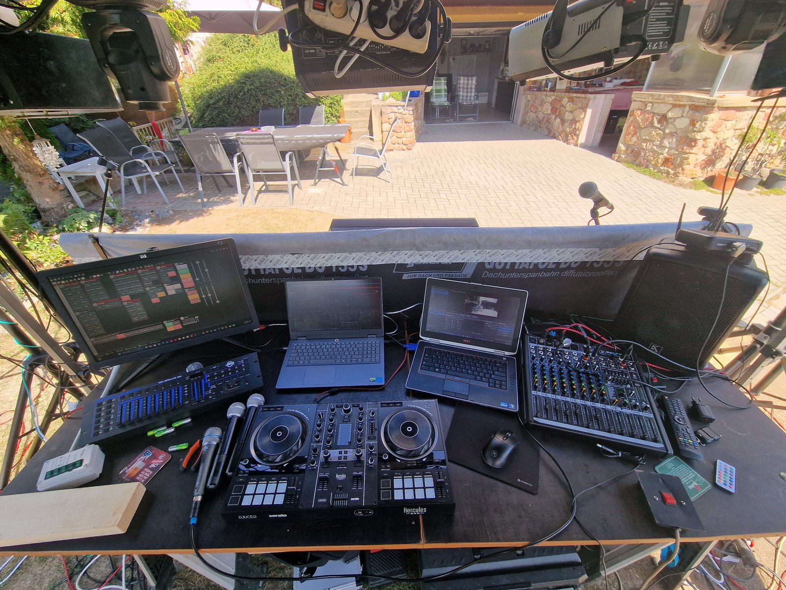 Pohled DJe od pultu — kontroler, notebooky, mixážní a světelný pult